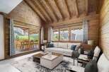 Experience the charm of this stunning property, featuring a cozy living room with a wooden ceiling and walls.
