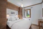 Discover the charm of this cozy bedroom, featuring a comfortable bed and a serene ambiance.