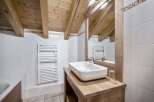 This charming bathroom features a rustic design with exposed wooden beams and a stylish sink.
