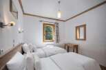 This cozy bedroom features two twin beds with crisp white linens, perfect for a comfortable stay.