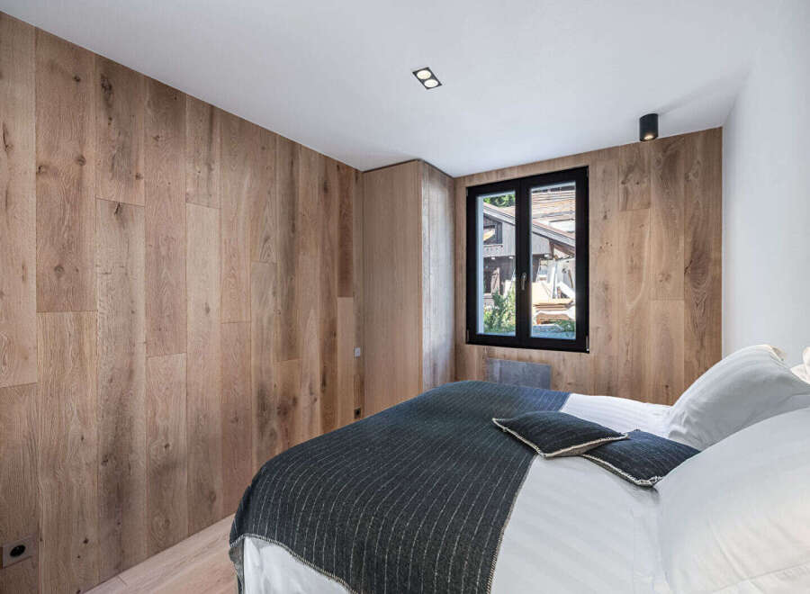 Experience the warmth and elegance of this stunning bedroom, featuring exquisite wood paneling that adds a touch of natural beauty.