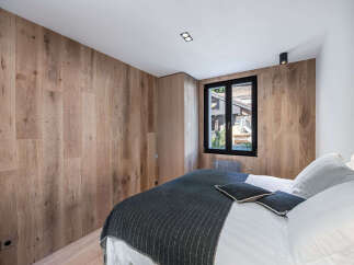 Experience the warmth and elegance of this stunning bedroom, featuring exquisite wood paneling that adds a touch of natural beauty.