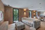 Experience luxury living in this stunning property, featuring a spacious living area with a modern, tufted sofa and ottoman.