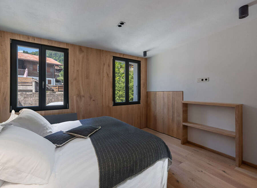 Experience the charm of this inviting bedroom, featuring natural wood accents and ample natural light.
