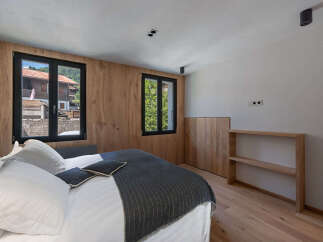 Experience the charm of this inviting bedroom, featuring natural wood accents and ample natural light.