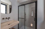 Step into a modern bathroom oasis! This stunning space features a sleek, frameless shower enclosure with black accents, complementing the contemporary design.