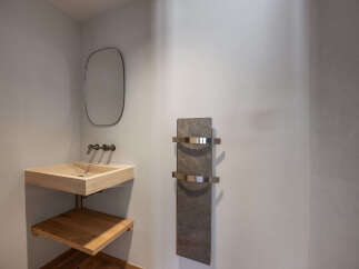 This modern bathroom features a sleek, minimalist design with a floating sink and a stylish towel warmer.