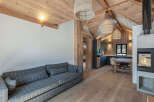 Experience the warmth and charm of this stunning property, featuring a cozy living area with a stylish gray plaid sofa.