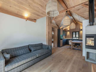 Experience the warmth and charm of this stunning property, featuring a cozy living area with a stylish gray plaid sofa.