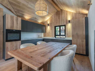This stunning kitchen boasts a rustic charm with its wooden ceiling, walls, and cabinetry, creating a warm and inviting atmosphere.