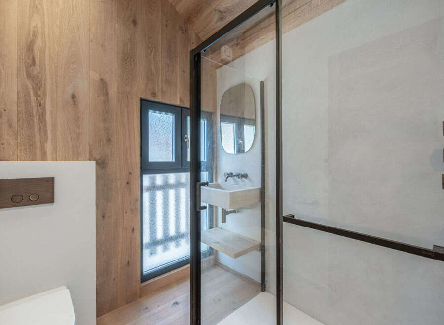 This modern bathroom boasts a sleek design with a glass shower enclosure and a stylish vanity.
