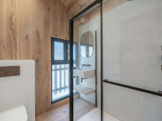 This modern bathroom boasts a sleek design with a glass shower enclosure and a stylish vanity.