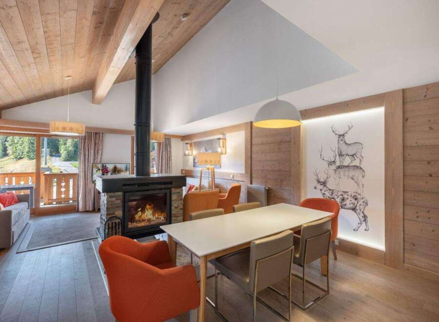 Experience the warmth of this stunning property, featuring a cozy fireplace and a stylish dining area.