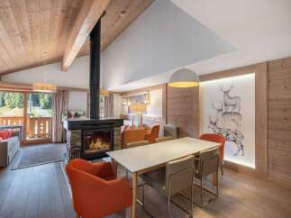 Experience the warmth of this stunning property, featuring a cozy fireplace and a stylish dining area.