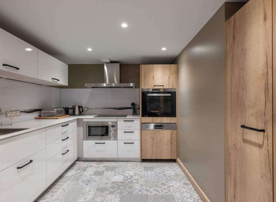 Discover modern living in this stylish kitchen! Featuring sleek white cabinetry, stainless steel appliances, and a stunning backsplash, this space is perfect for culinary enthusiasts.