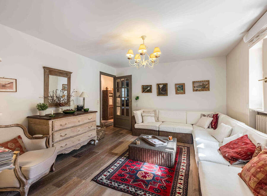 This charming living room boasts a cozy atmosphere with its inviting sectional sofa and a vibrant rug that adds a pop of color.