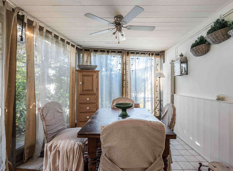 Step into this charming dining room, bathed in natural light and adorned with elegant curtains.