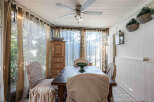 Step into this charming dining room, bathed in natural light and adorned with elegant curtains.