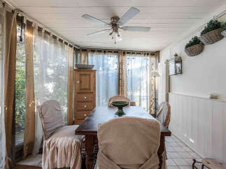 Step into this charming dining room, bathed in natural light and adorned with elegant curtains.