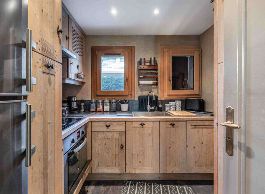 This charming kitchen boasts rustic wooden cabinetry and a stainless steel sink, creating a warm and inviting atmosphere.
