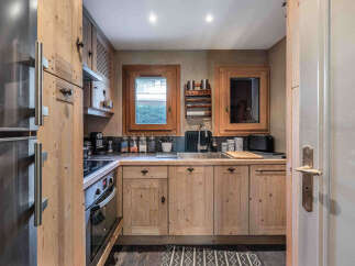 This charming kitchen boasts rustic wooden cabinetry and a stainless steel sink, creating a warm and inviting atmosphere.