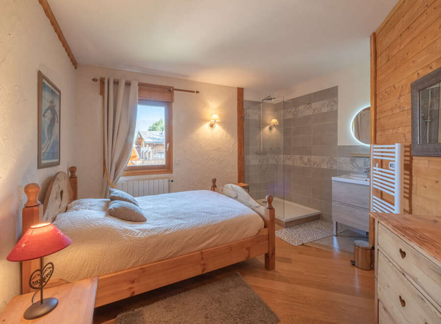 Experience the charm of this cozy bedroom, featuring a comfortable bed and a private bathroom.