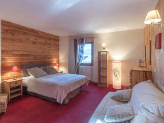 This cozy bedroom features a warm wooden accent wall, creating a rustic and inviting atmosphere.