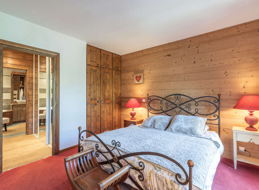 This charming bedroom features a cozy ambiance with its wooden paneling and warm lighting.