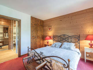 This charming bedroom features a cozy ambiance with its wooden paneling and warm lighting.