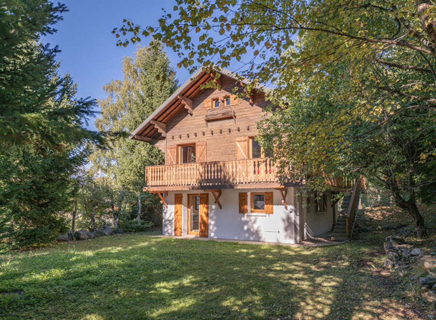 Nestled amidst lush greenery, this charming wooden chalet offers a serene escape.