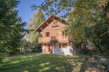 Nestled amidst lush greenery, this charming wooden chalet offers a serene escape.