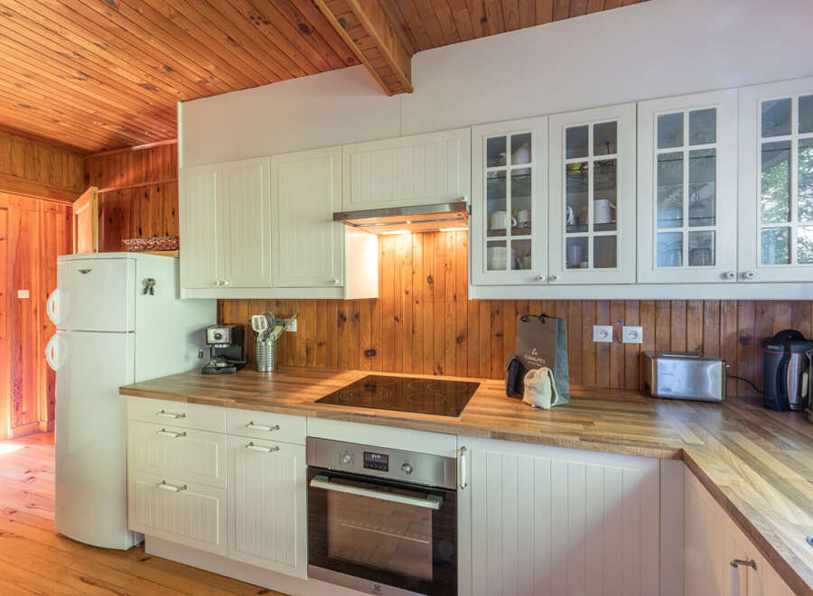 This charming kitchen boasts a warm, inviting atmosphere with its wooden accents and ample natural light.
