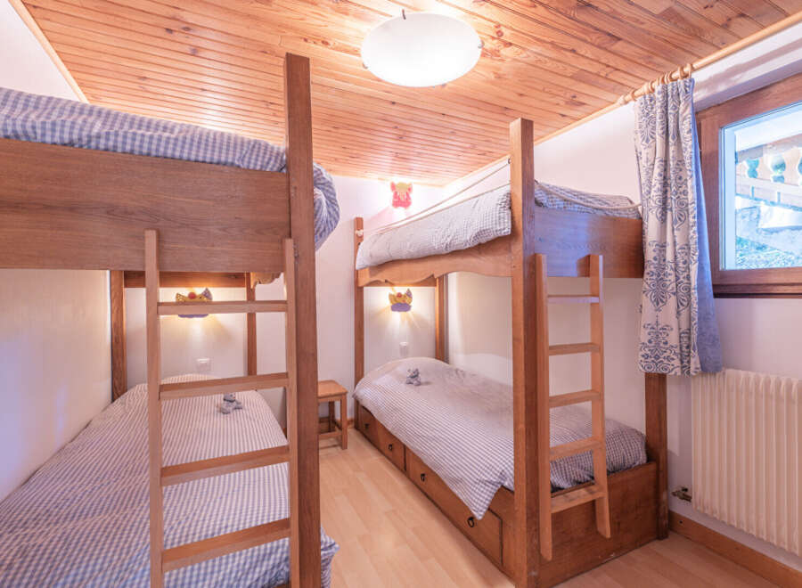 This charming bedroom features two sets of bunk beds, perfect for accommodating multiple guests or family members.