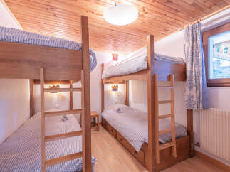 This charming bedroom features two sets of bunk beds, perfect for accommodating multiple guests or family members.