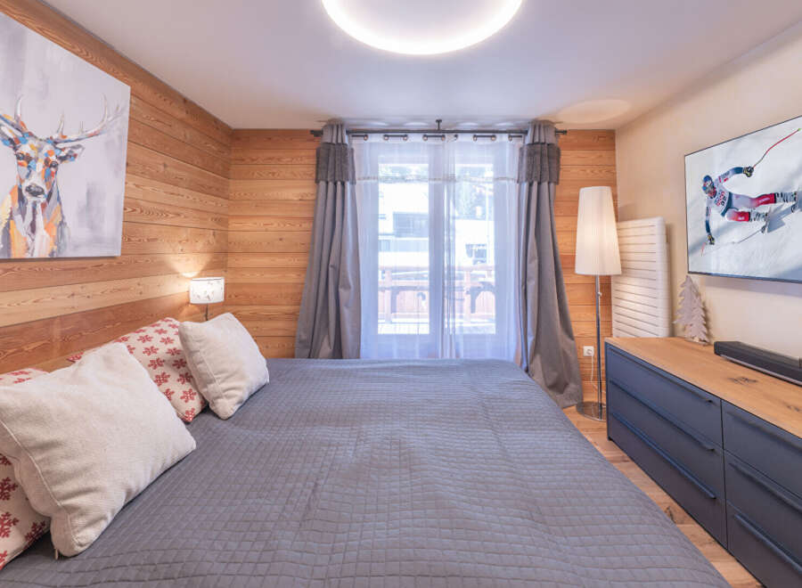 Experience the charm of this cozy bedroom, featuring a comfortable bed and a stylish deer artwork.