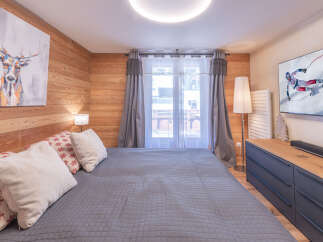 Experience the charm of this cozy bedroom, featuring a comfortable bed and a stylish deer artwork.