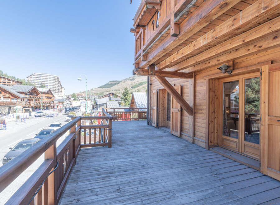 Experience the charm of this stunning wooden chalet with a spacious deck overlooking a picturesque mountain town.