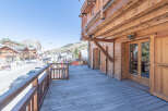 Experience the charm of this stunning wooden chalet with a spacious deck overlooking a picturesque mountain town.