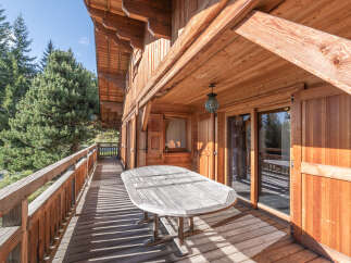 Enjoy the tranquility of this stunning wooden chalet, featuring a spacious deck perfect for outdoor dining and relaxation.