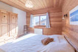 This cozy bedroom features beautiful wooden paneling on the walls and ceiling, creating a warm and inviting atmosphere.