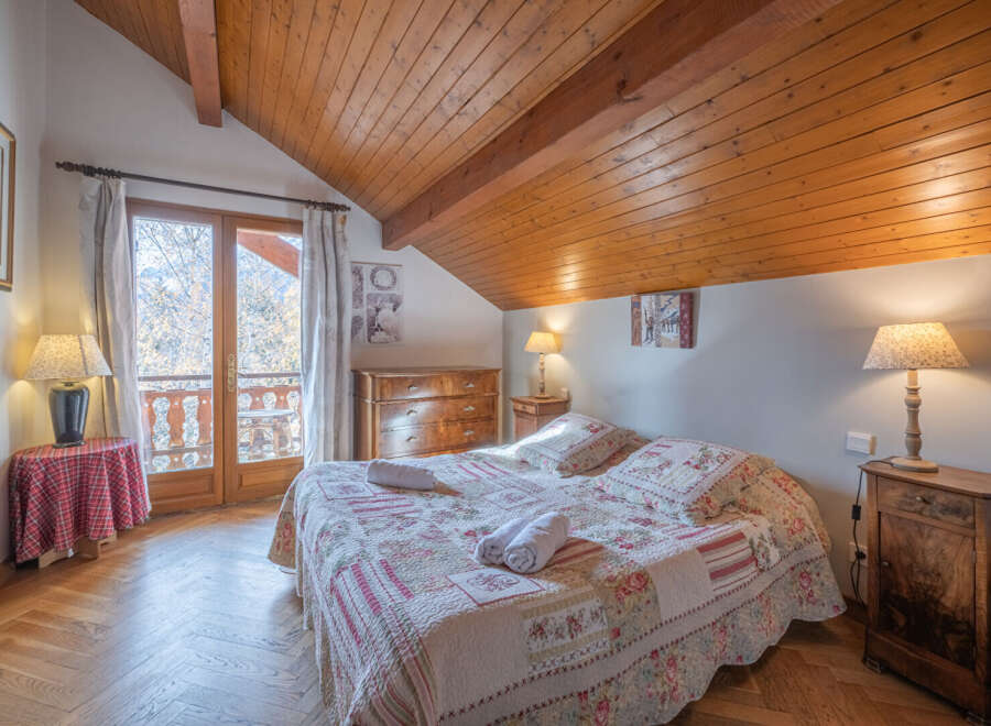 This charming bedroom features a cozy bed with floral bedding, perfect for a relaxing stay.