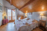 This charming bedroom features a cozy bed with floral bedding, perfect for a relaxing stay.