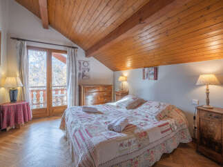 This charming bedroom features a cozy bed with floral bedding, perfect for a relaxing stay.