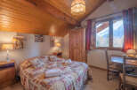 This charming bedroom features a cozy, rustic design with a wooden ceiling and a comfortable bed.