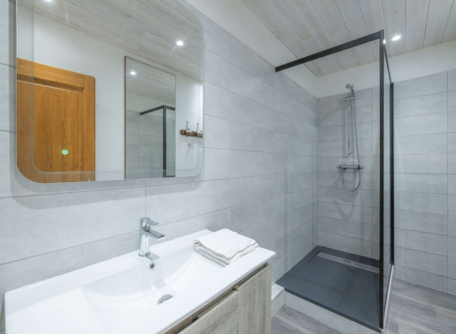 Step into this modern bathroom, featuring a sleek shower enclosure and stylish vanity.