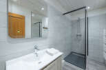 Step into this modern bathroom, featuring a sleek shower enclosure and stylish vanity.