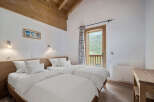 This charming bedroom features two comfortable beds with crisp white linens, perfect for a relaxing stay.