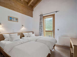 This charming bedroom features two comfortable beds with crisp white linens, perfect for a relaxing stay.