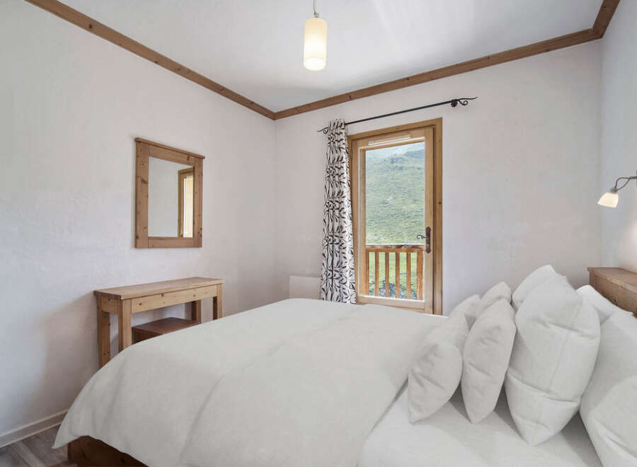 This cozy bedroom features a comfortable bed with plush pillows, perfect for a relaxing retreat.