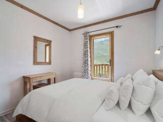 This cozy bedroom features a comfortable bed with plush pillows, perfect for a relaxing retreat.